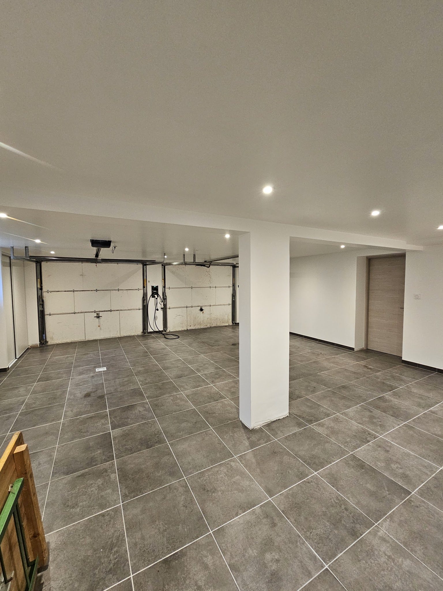 Grande pièce carrelée aux murs et plafond blancs
